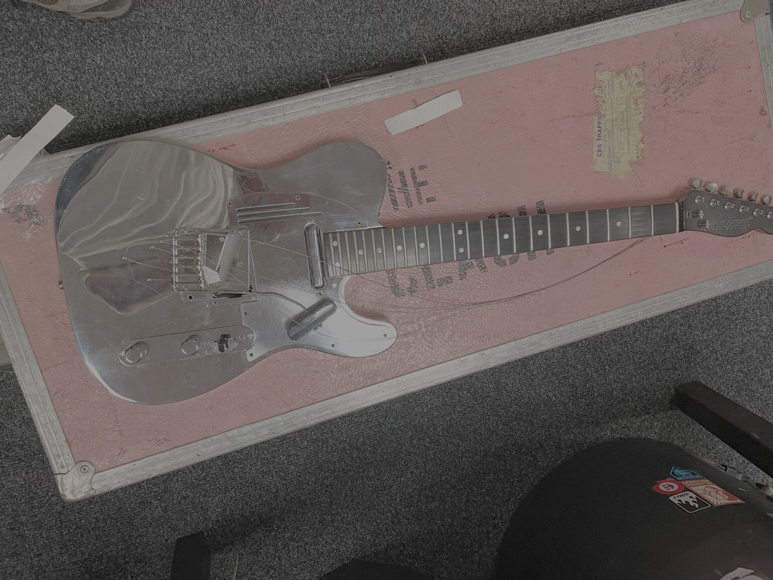 Metal-bodied guitar in its workshop case